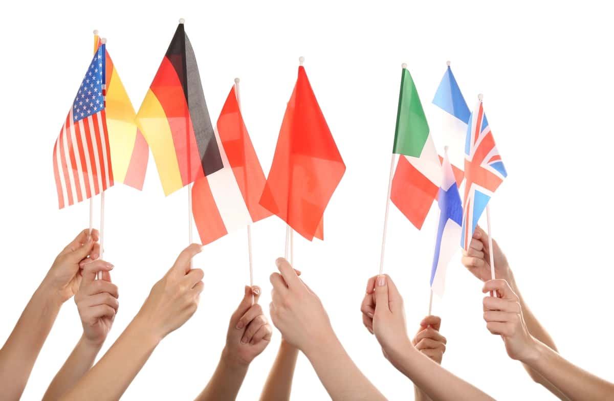 Turli xil bayroqlarni ushlab turgan qo'llar oq rangda | Hands holding different flags isolated white 1