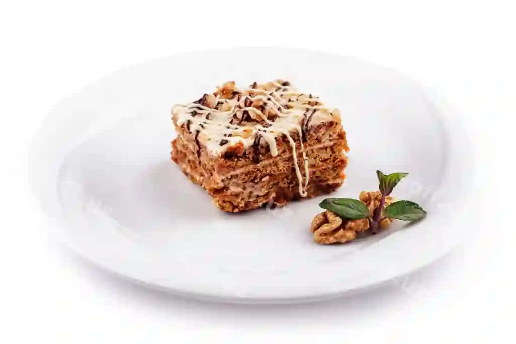 Oq likopchada o'tirgan yong'oqli mazali shokoladli tort | Delicious cake with walnuts chocolate drizzle sitting white plate