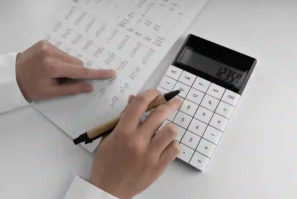 Kalkulyatordan foydalangan buxgalter moliyaviy hisobotni barmoq raqamlari bilan ko'rsatmoqda | Accountant using calculator points her finger numbers financial statement