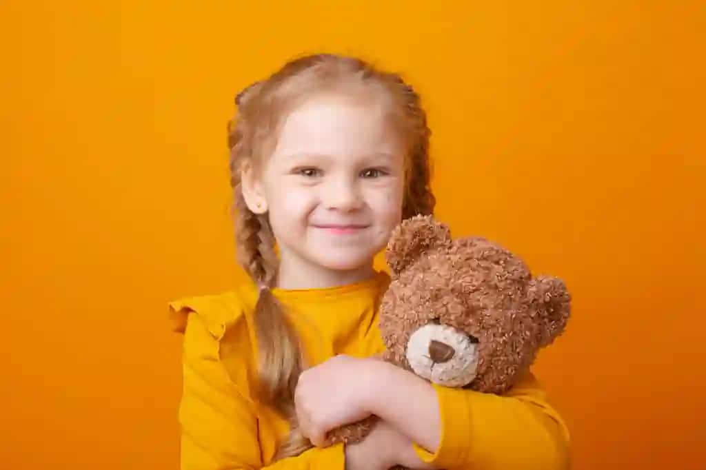 Yoqimtoy kichkina qizcha sariq fonda ayiqchani quchoqlab turibdi | Cute little girl holding teddy bear yellow background hugging