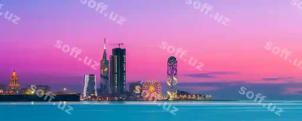 Yorqin shahar dengiz yonida osmon quyosh botirganda | Illuminated city by sea against sky sunset