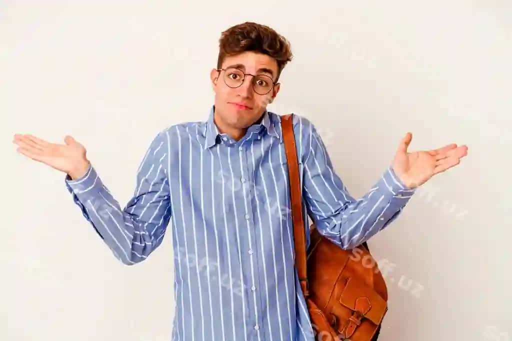 Yosh talaba yigit oq devorni izolyatsiya qilgan holda yelka qisib, imo-ishorani so'roq qilishiga shubha qilmoqda | Young student man isolated white wall doubting shrugging shoulders questioning gesture