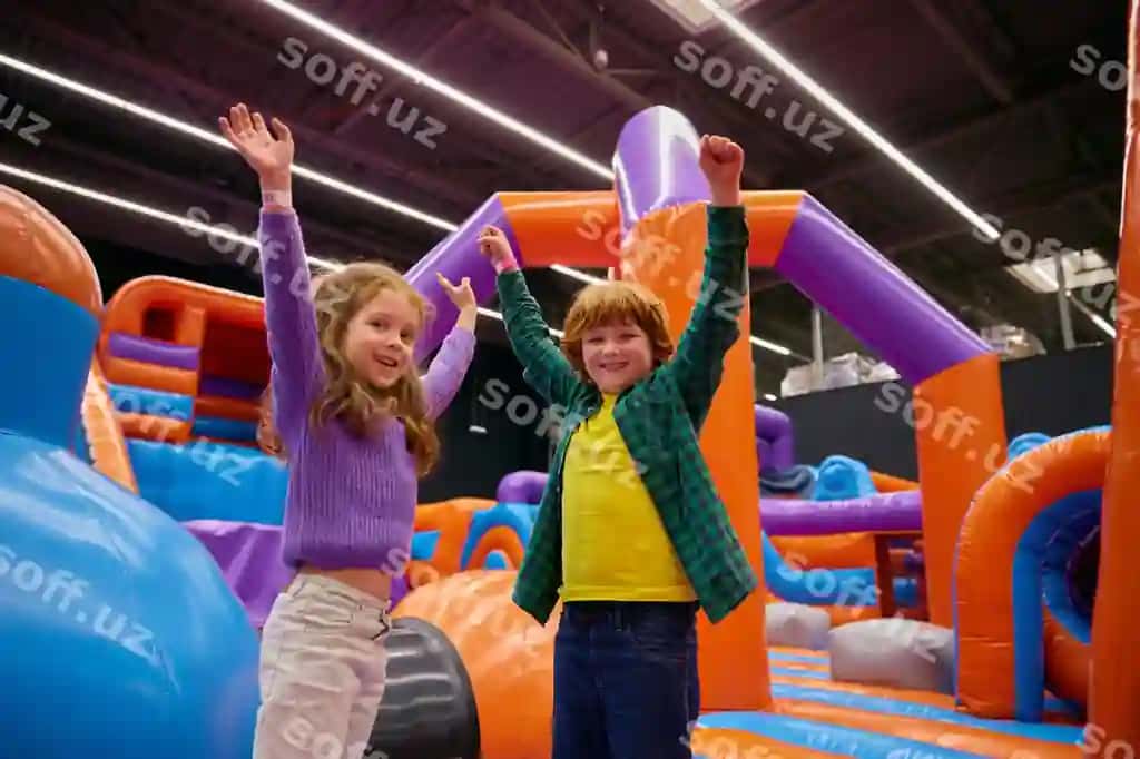 Portret baxtli bolalar ko'tarilgan qo'llari bilan bounce house o'yin oynayotgan | Portrait happy children with raised hands up playing bounce house