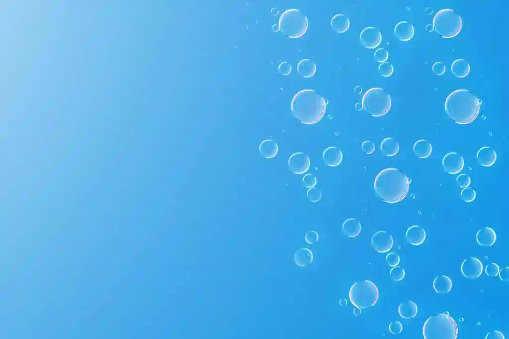 Havo pufakchalari suv hyaluron kislotasi kosmetik yog'i ko'k fonni tushiradi | Air bubbles waterhyaluronic acid cosmetic oil drops blue background