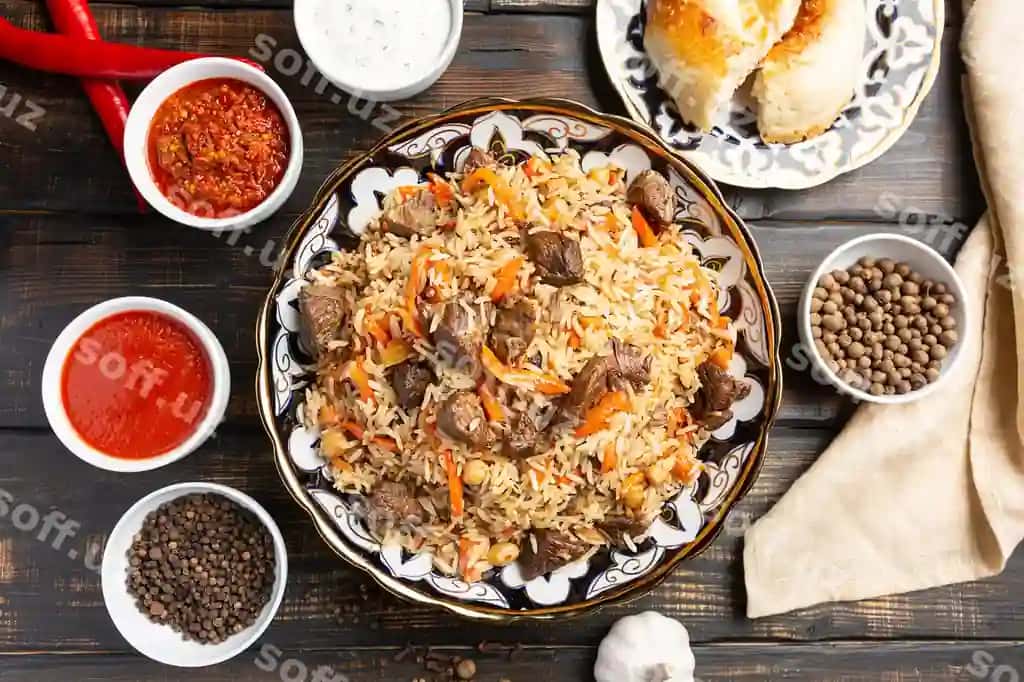 O'zbek palovli guruchli taom qovurilgan piyoz bilan qovurilgan mol go'shti bilan tayyorlangan sarimsoq sabzi guruch quritilgan mevalar sarimsoq zira | Uzbek plov rice dish prepared with beef stewed with fried onions garlic carrots rice dried fruits garlic cumin