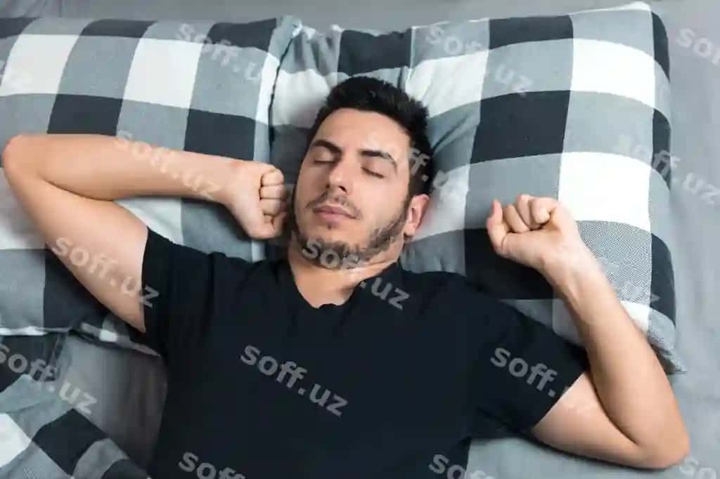 Yuqori ko'rinishda chiroyli erkak chimsa uhlashda havalanadi va ko'zlari bilan massqotiradi. | Top view handsome man yawns rubs his eyes while sleeping bed