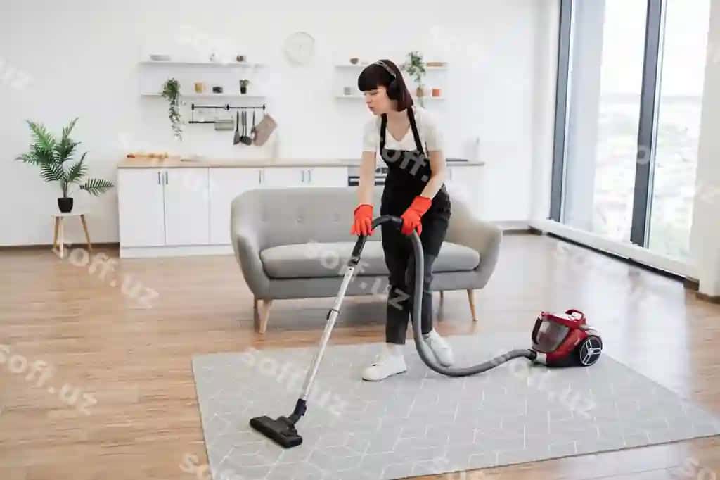 Tozalash xizmati xodimi keng ochiq uyda tozalashda musiqani eshitadi. | Cleaning service employee listens music while cleaning spacious apartment