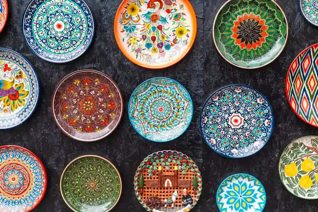 Qadimgi an'anaviy o'zbek anjomlari devoridagi milliy gulli naqshlar bilan bezatilgan likopchalar | Ancient traditional uzbek utensils plates wall with national floral ornament