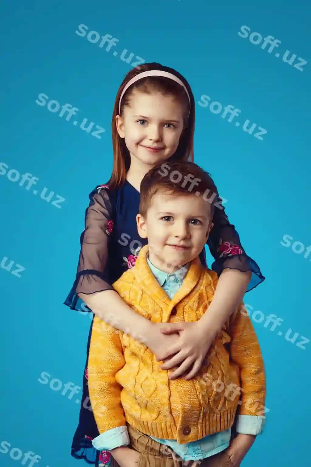 Singil ko'k rangli ko'ylak o'g'li bilan o'pishgan ajraltirilgan ko'k fon | Sister blue dress embracing her brother isolated blue background