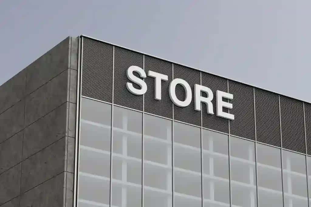 Kulrang beton devorli zamonaviy do'kon binosining jabhasi katta oyna bo'limidagi do'kon belgisi 3D renderlash | Modern store building facade with gray concrete wall large window section store sign 3d rendering