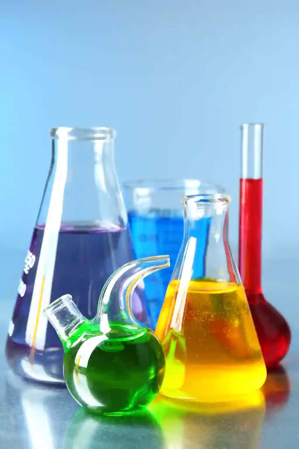 Rangli suyuq rangli sirtga ega turli xil laboratoriya shisha idishlari | Different laboratory glassware with colorful liquid color surface