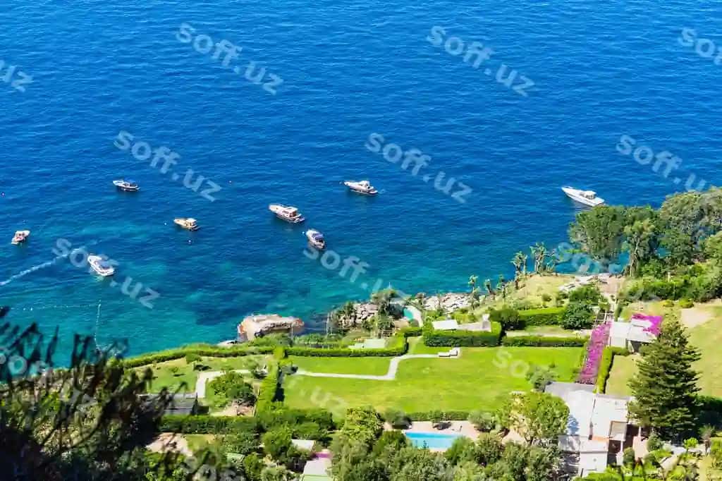 Havodan Capri sahil ko'rinishi Foinik chollari orqali, zirvak rangli suvlarda qodirjalarning suzilishi bilan Italiyada. | Aerial view capri coastline from phoenician steps with boats sailing turquoise waters italy