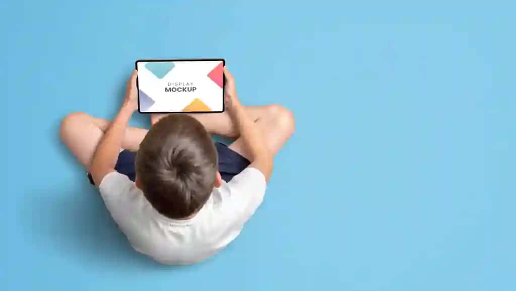 Planshet maketining tepadan ko‘rinishini ushlab turgan bola | Boy holding tablet mockup top view