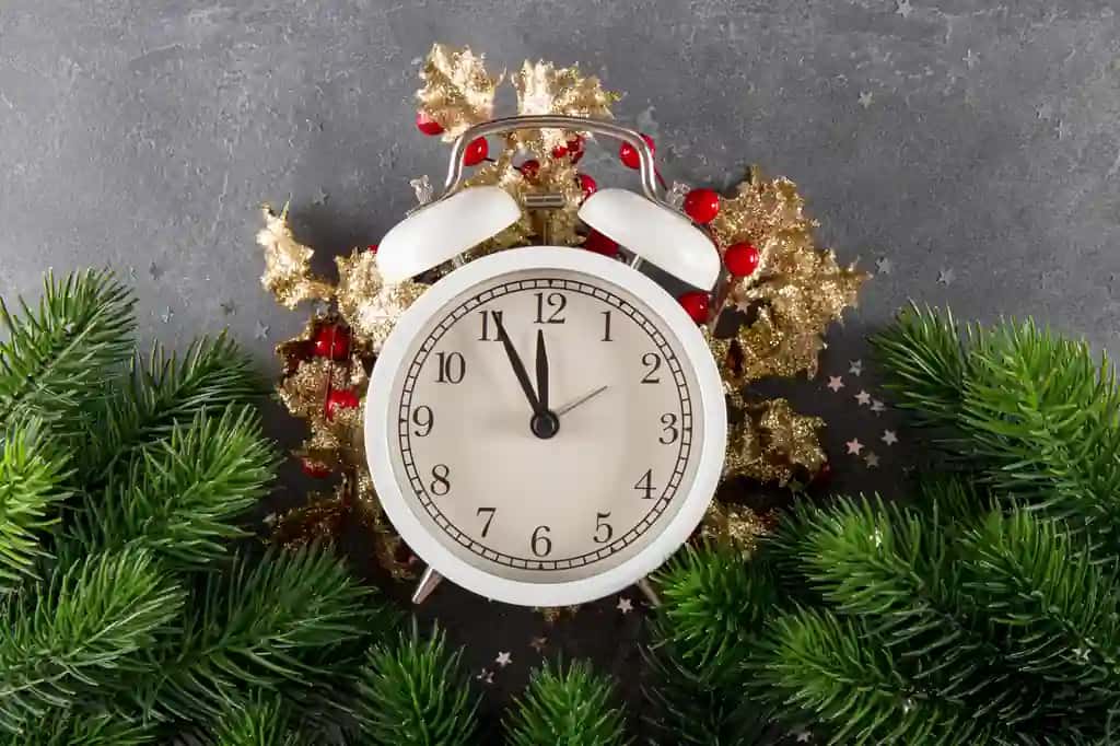 Rojdestvo fonida Rojdestvo yozuvi bilan Rojdestvo soati archa shoxlari keladi | Christmas background with inscription christmas is coming clock fir branches christmas