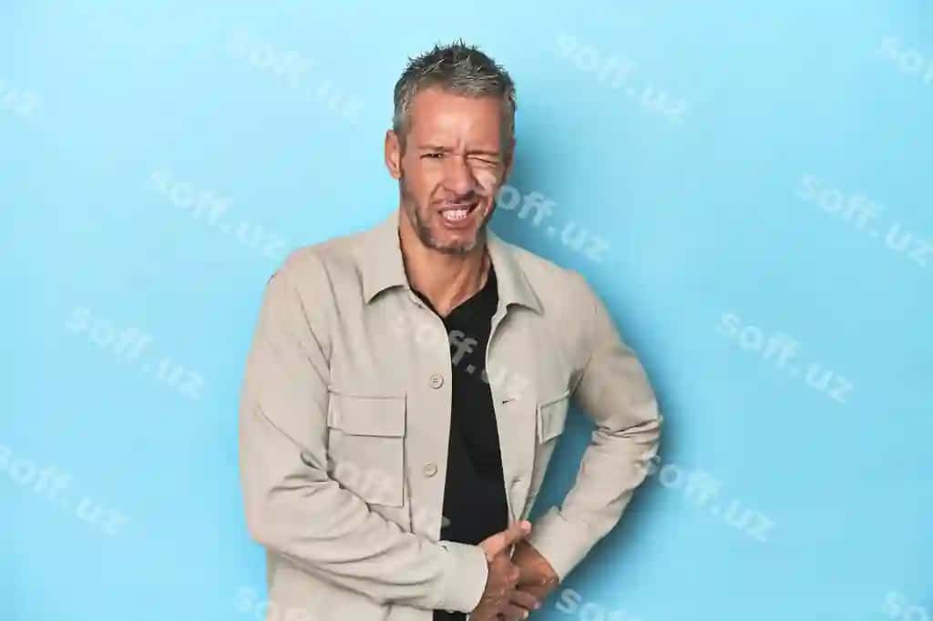 O'rta yosh qizil teriylı erkak ko'k orqa fonda jigarrı og'rig'ini va cho'chqon og'rig'ini | Middleaged caucasian man blue backdrop having liver pain stomach ache