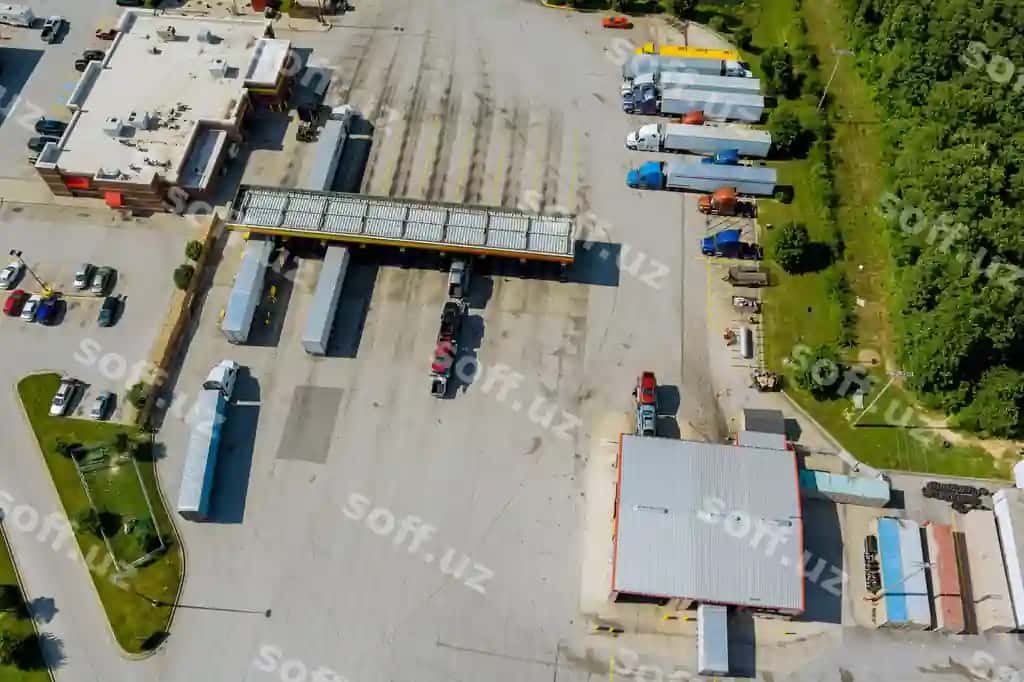 Yuk mashinalari yoqilg'i quyish shoxobchasi bilan havodan ko'rinadigan transport yoqilg'i quyish shoxobchasi, shtatlararo avtomagistral yaqinida yuk mashinalari to'xtaydi | Aerial view transportation gas station with truck fueling station truck stop near interstate h