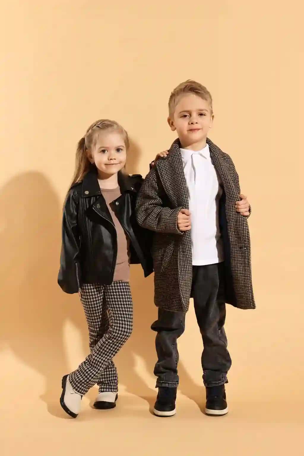 Moda kontseptsiyasi zamonaviy bolalar rangpar to'q sariq fonda | Fashion concept stylish children posing pale orange background