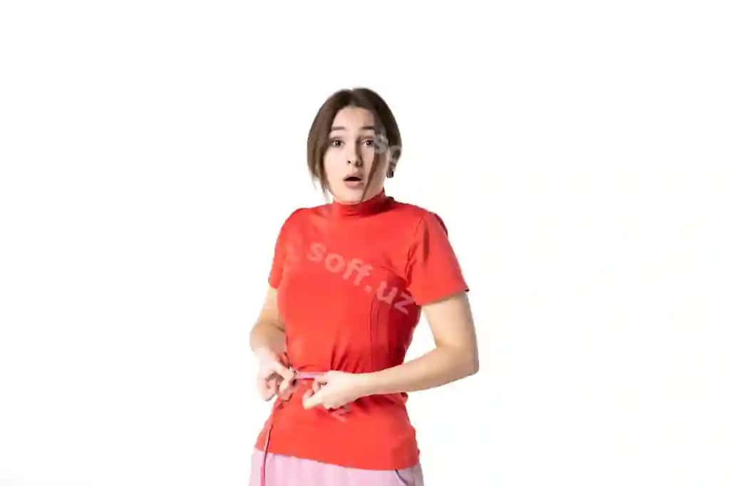 Old tomondan ko'rinish: Hayratlangan yosh ayol qizil-orange rangli bluzka kirib o'tgan metrda o'zining belini o'lchamoqda. Oq fonda. | Front view shocked young lady redorange blouse holding metre measuring her waist white background