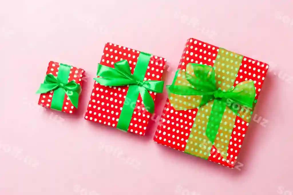 Yuqori ko'rinishdagi Rojdestvo sovg'asi qutisi yashil kamon pushti fon bilan | Top view christmas present box with green bow pink background