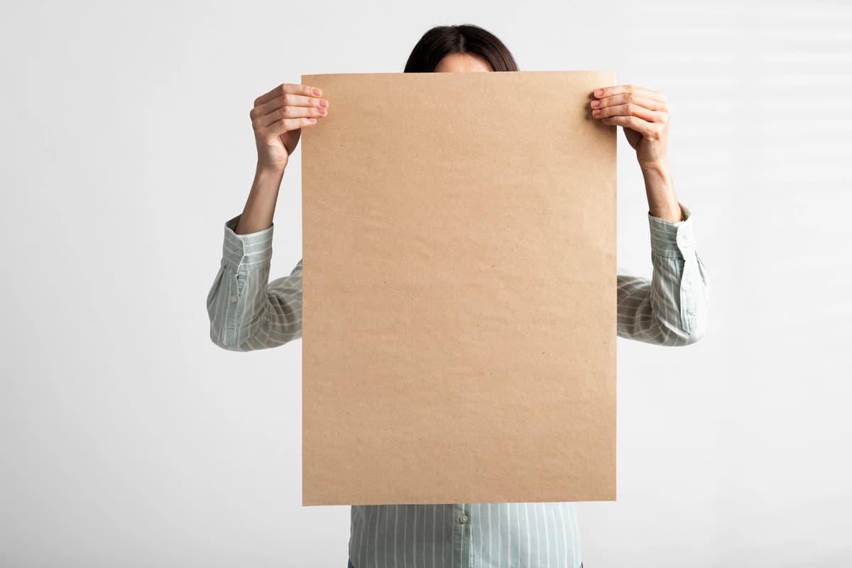 Qayta ishlangan qog'ozdan chizilgan tabelani ushlab turgan odam | Person holding signboard with drawing from recycled paper