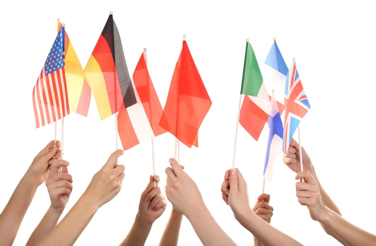 Turli xil bayroqlarni ushlab turgan qo'llar oq rangda | Hands holding different flags isolated white