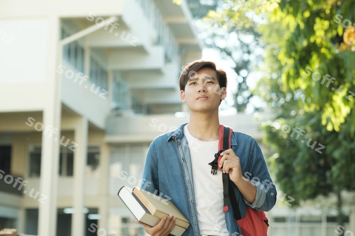 Talaba tashqarida kitoblarni tutgan | Student standing outdoor holding books