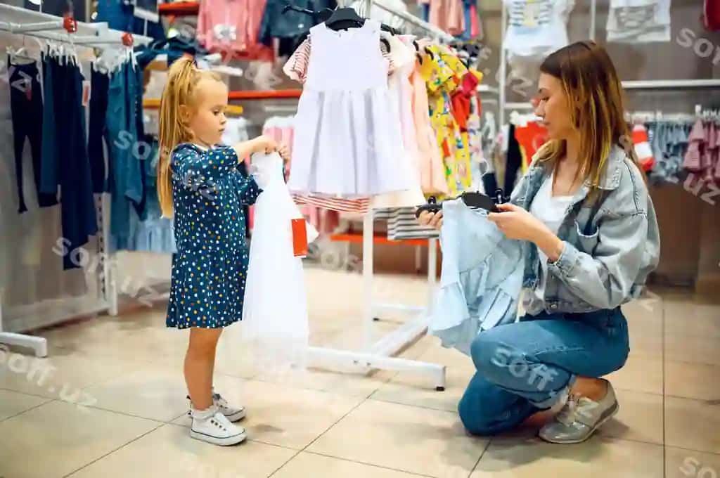 Ona kichik bolasi uchun bolalar do'konida kiyim sotib olayotgan. | Mother little baby buying dress kid s store